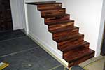 Contempory american black walnut cut string staircase waiting for frameless glass balustrade